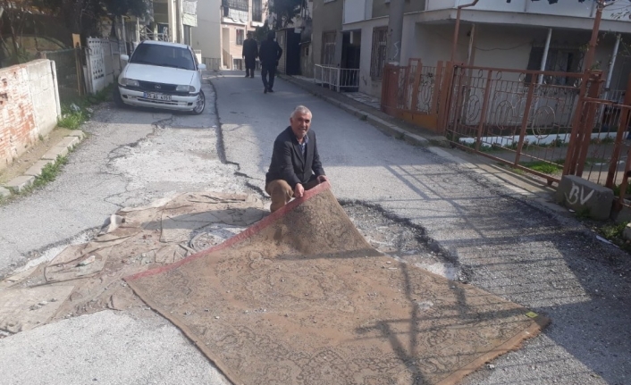 Asfalt bekleyen bozuk yola halı serdiler
