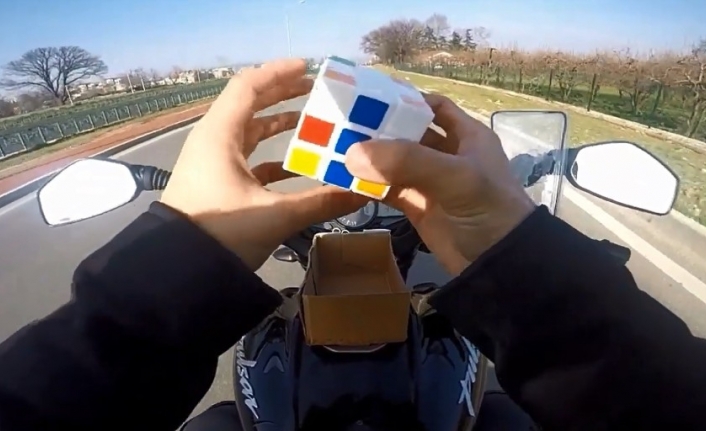Motosiklet üzerinde rubik küp çözdü, oyun oynadı