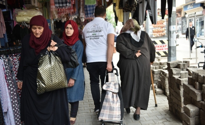 Belediye ekipleri, yaşlıların torbalarını taşıyor