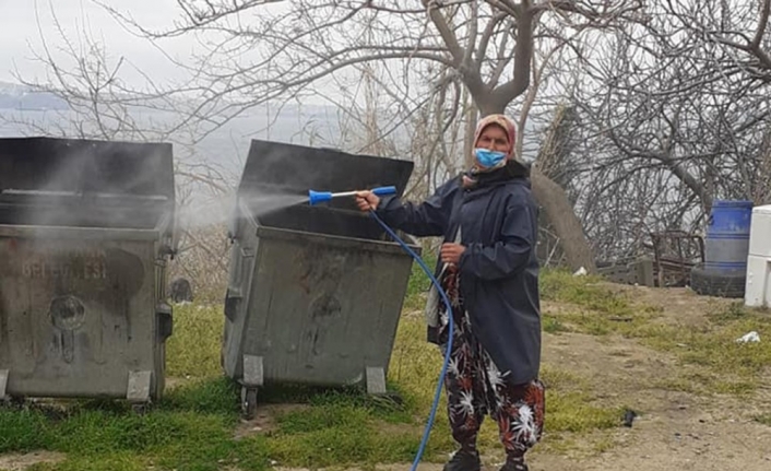 Kadın muhtar mahallesini dezenfekte ediyor