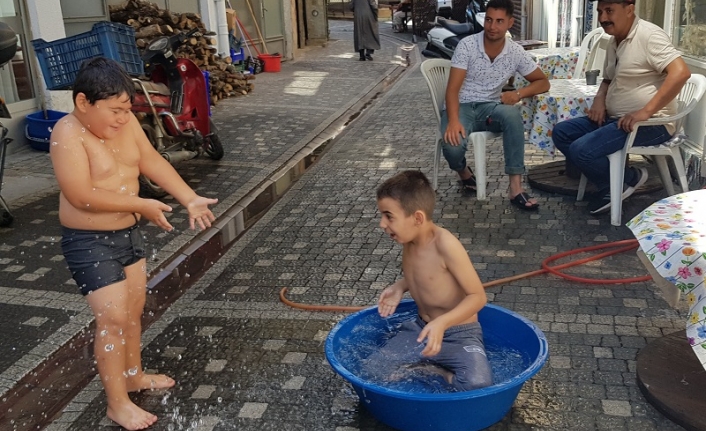 Edremit’te sıcaktan bunalan çocuklar leğende serinledi